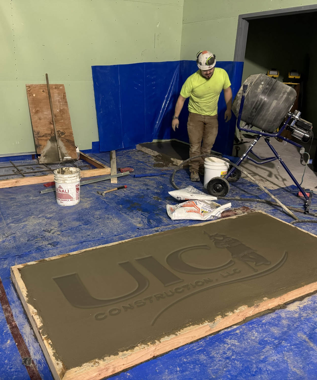 Construction worker indoors working with poured concrete.